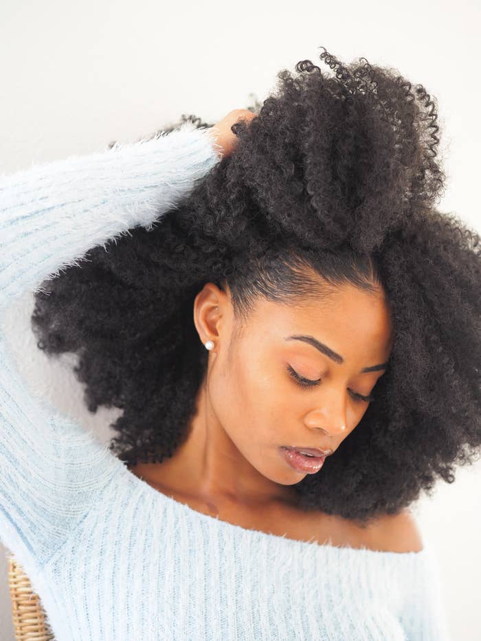 closeup of a Black woman pushing back her curls