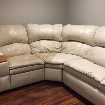 reviewer photo showing their white sectional half dirty, half cleaning restored after using the leather honey