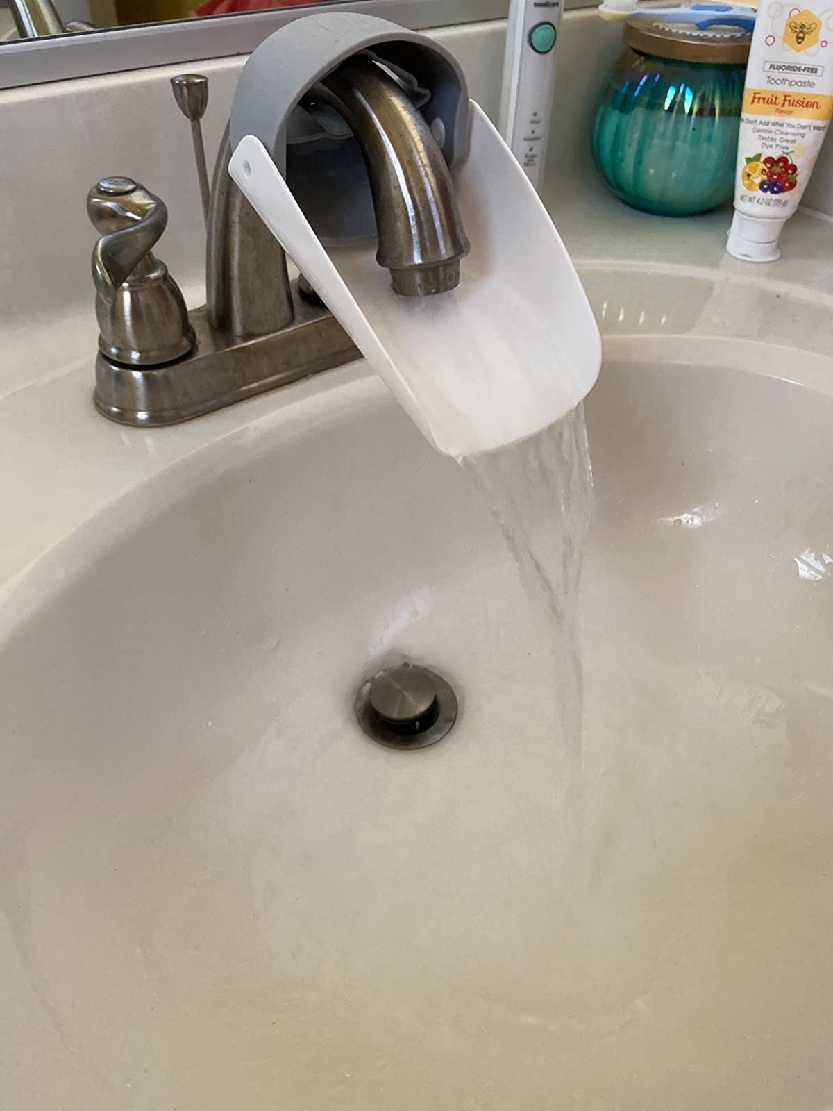 Reviewer&#x27;s photo of the faucet extender in use on a faucet