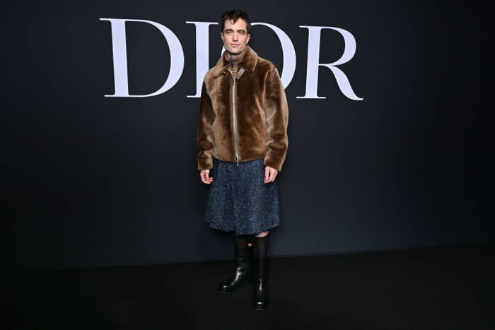 Robert poses for photographers at the Dior Fall-Winter show in the zip-up jacket and a knee-length skirt and boots