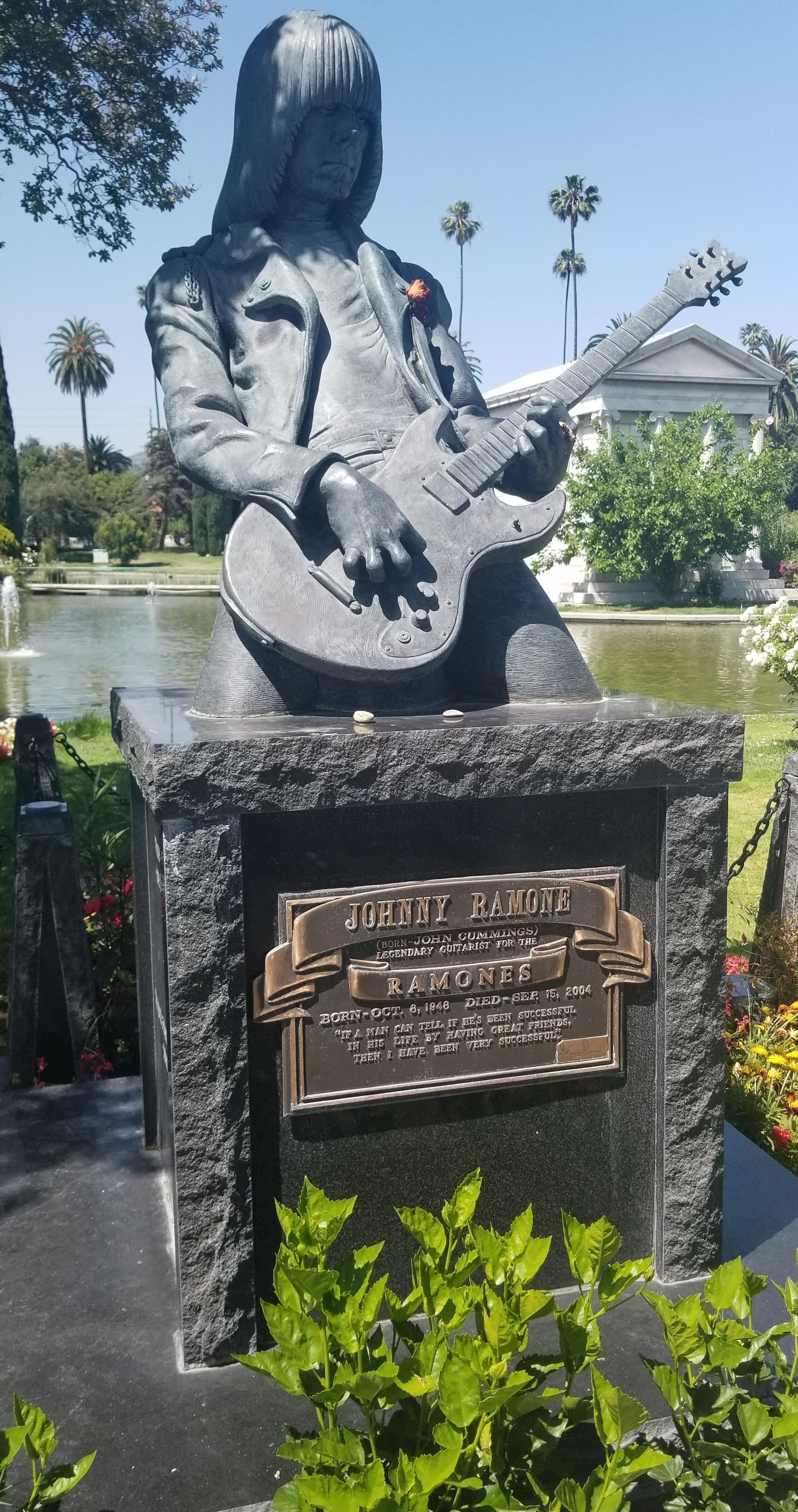 A large grave with a sculpture of the musician playing guitar on top