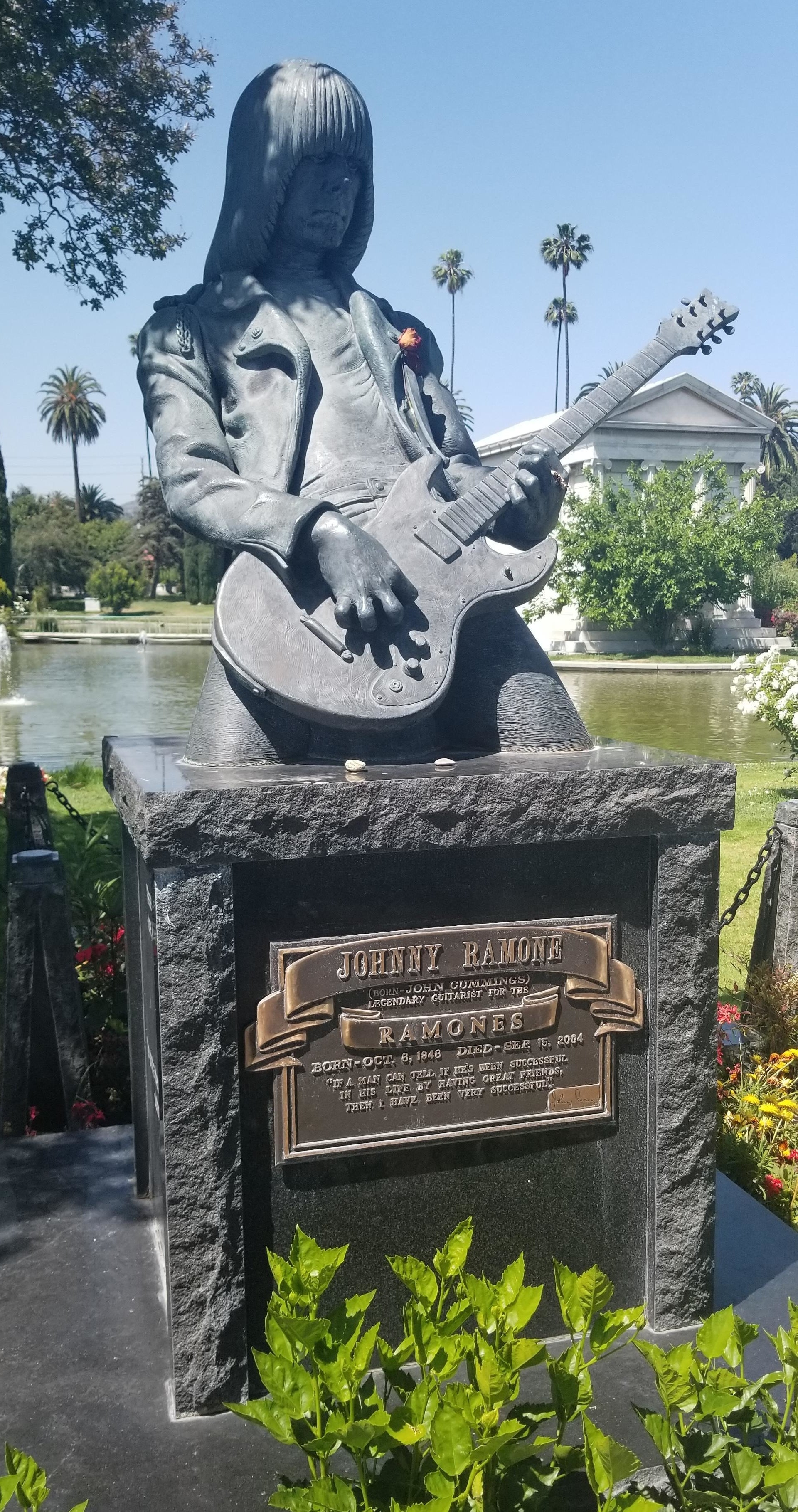 A large grave with a sculpture of the musician playing guitar on top