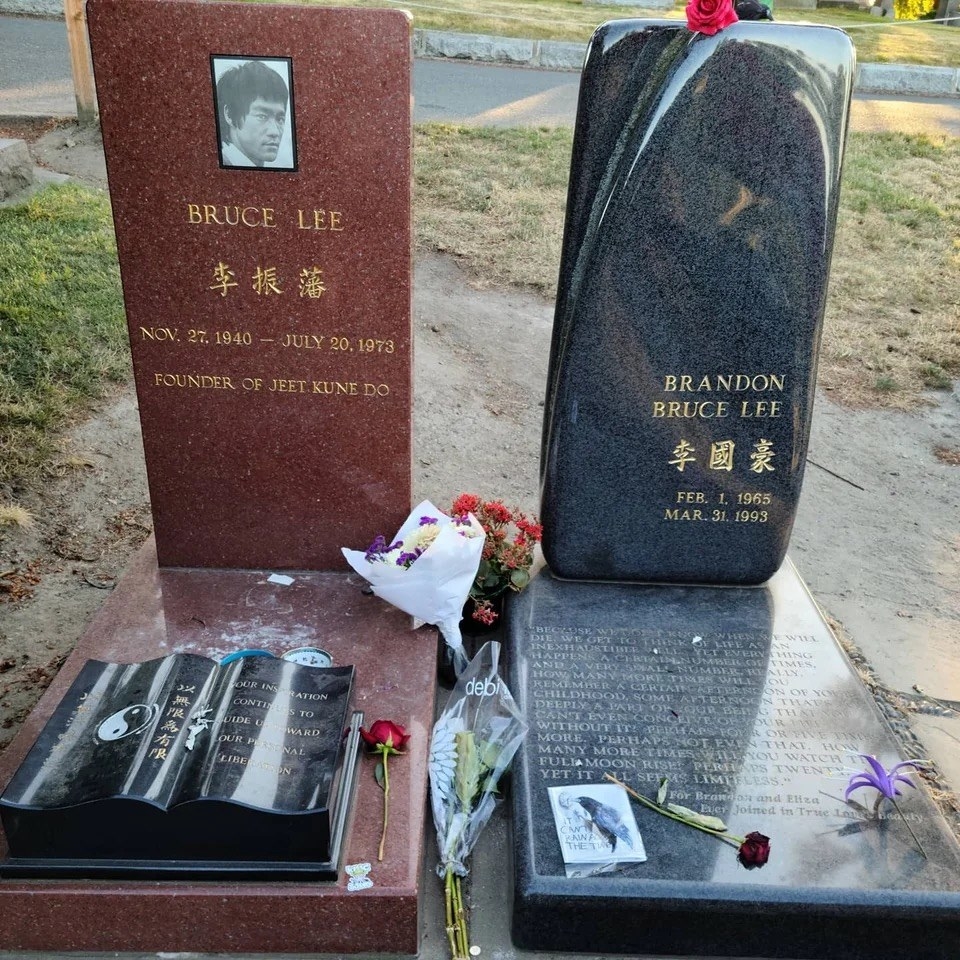 Bruce&#x27;s grave with polished red stone, and a stome book, brandon&#x27;s with dark grey stone and a lot of text below it
