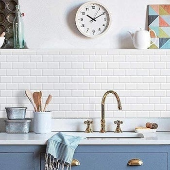 The tiles in white installed on a wall behind a sink