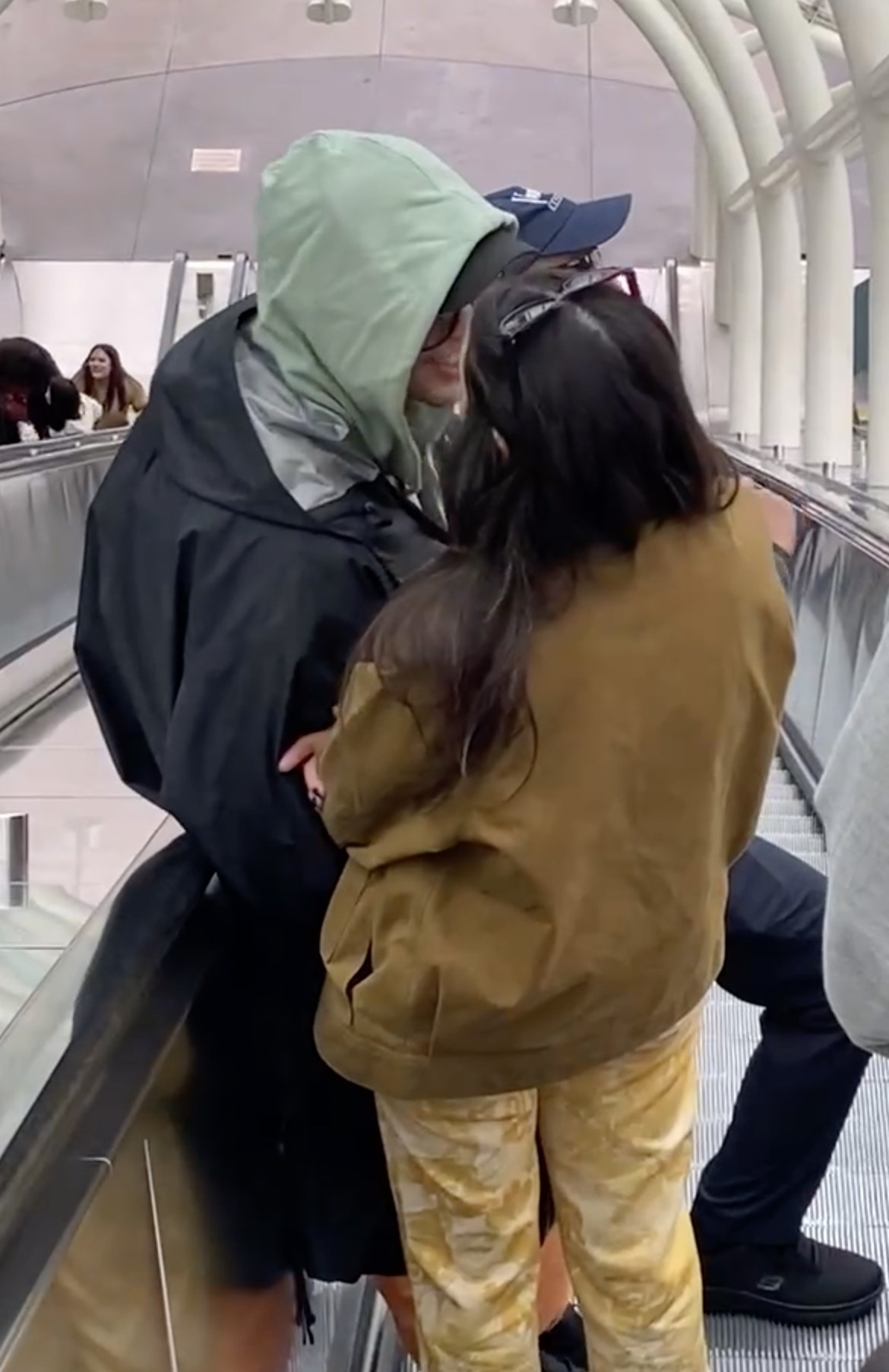 the pair cozying up on the escalator