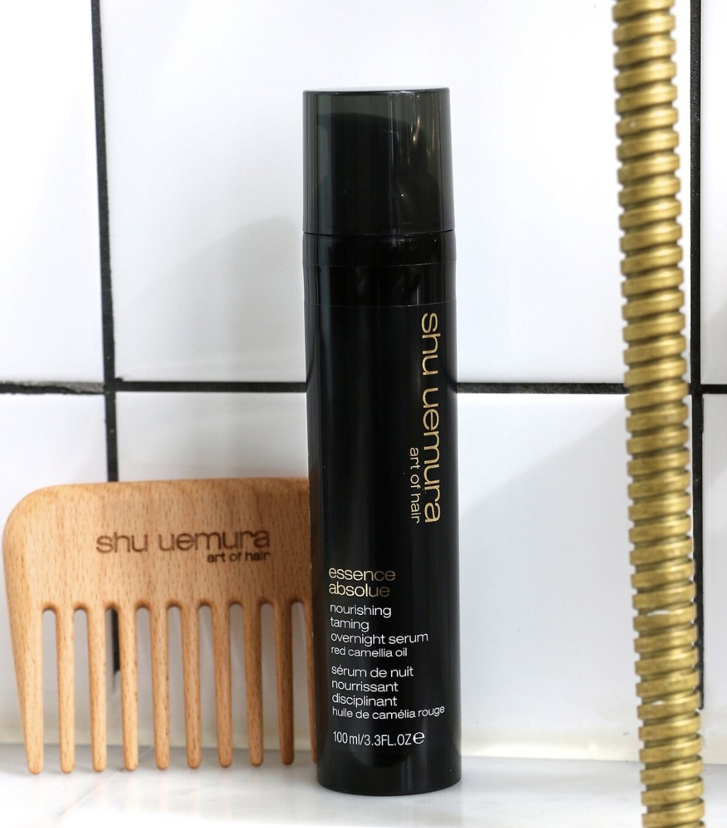 A wooden comb and a bottle of hair treatment