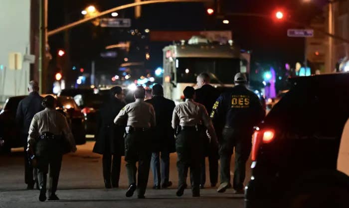 A group of officers walk away from the camera at the scene of a mass shooting in los angeles