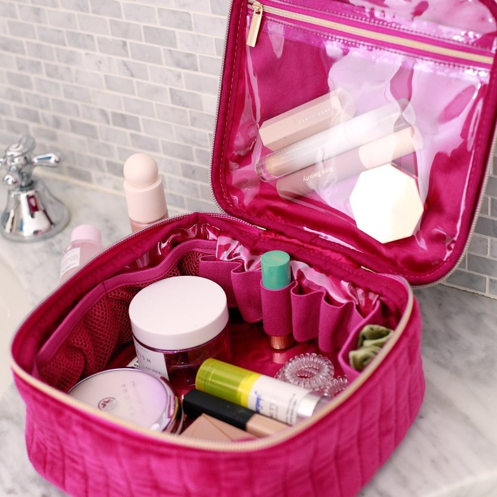 the zippered makeup bag open to show off the many compartments and pockets inside