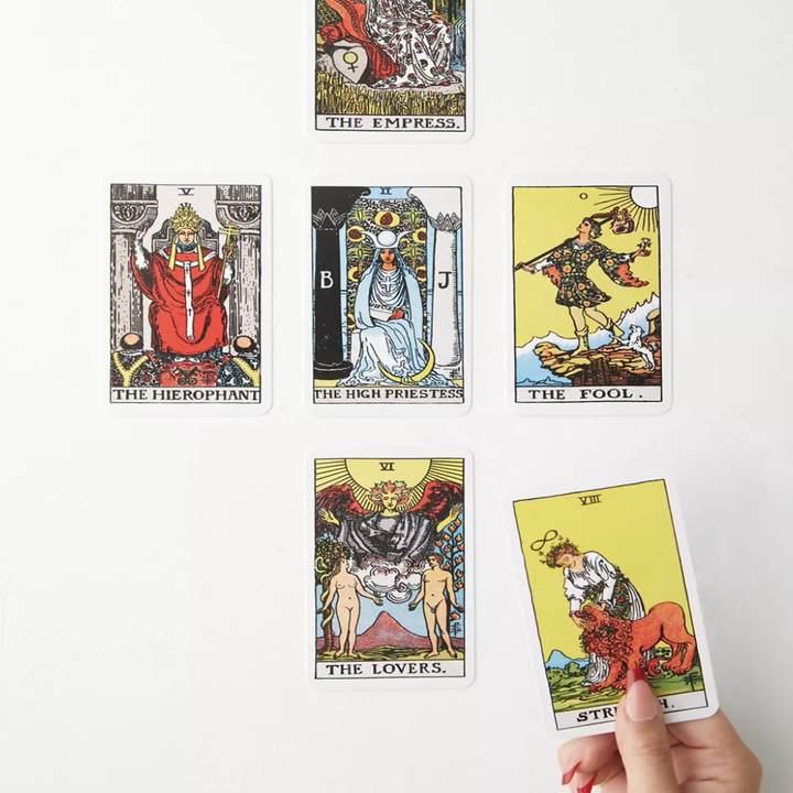 a person holding a card over other cards on a plain background
