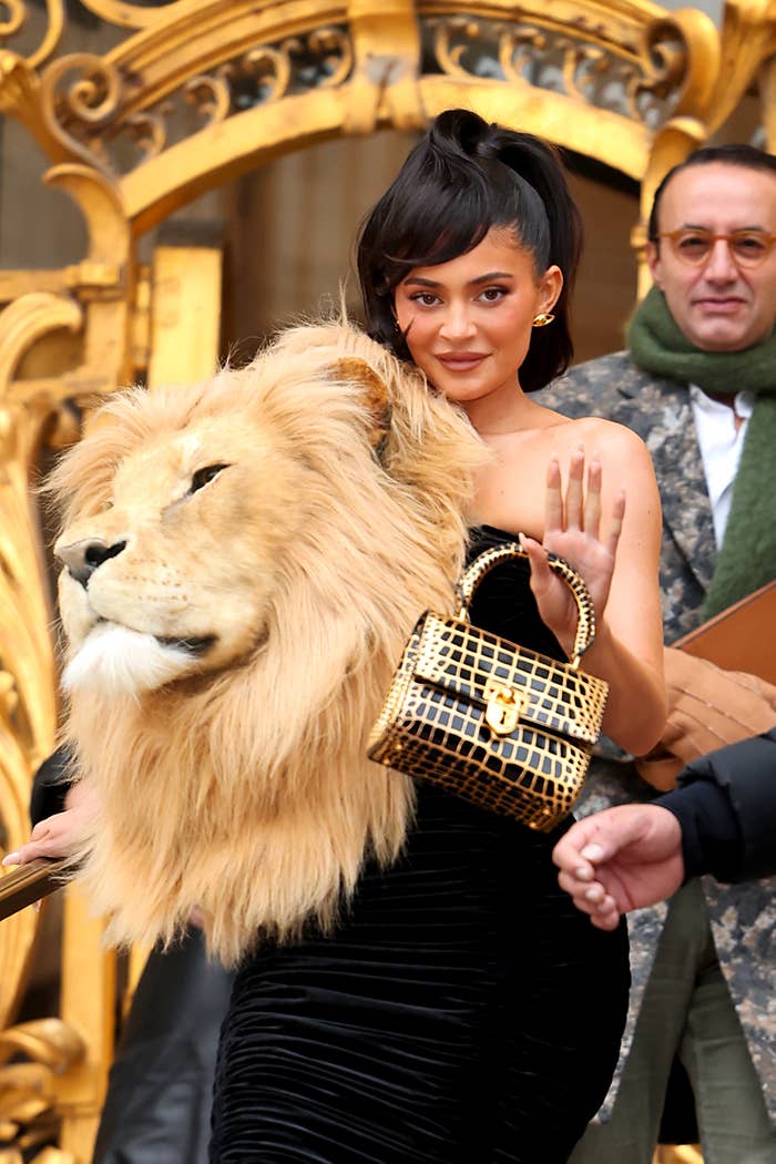 Kylie waves to the cameras as she walks down steps in her Sciaparelli dress