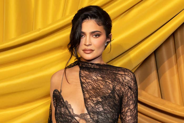 Kylie in a lace-one-shouldered gown and an updo