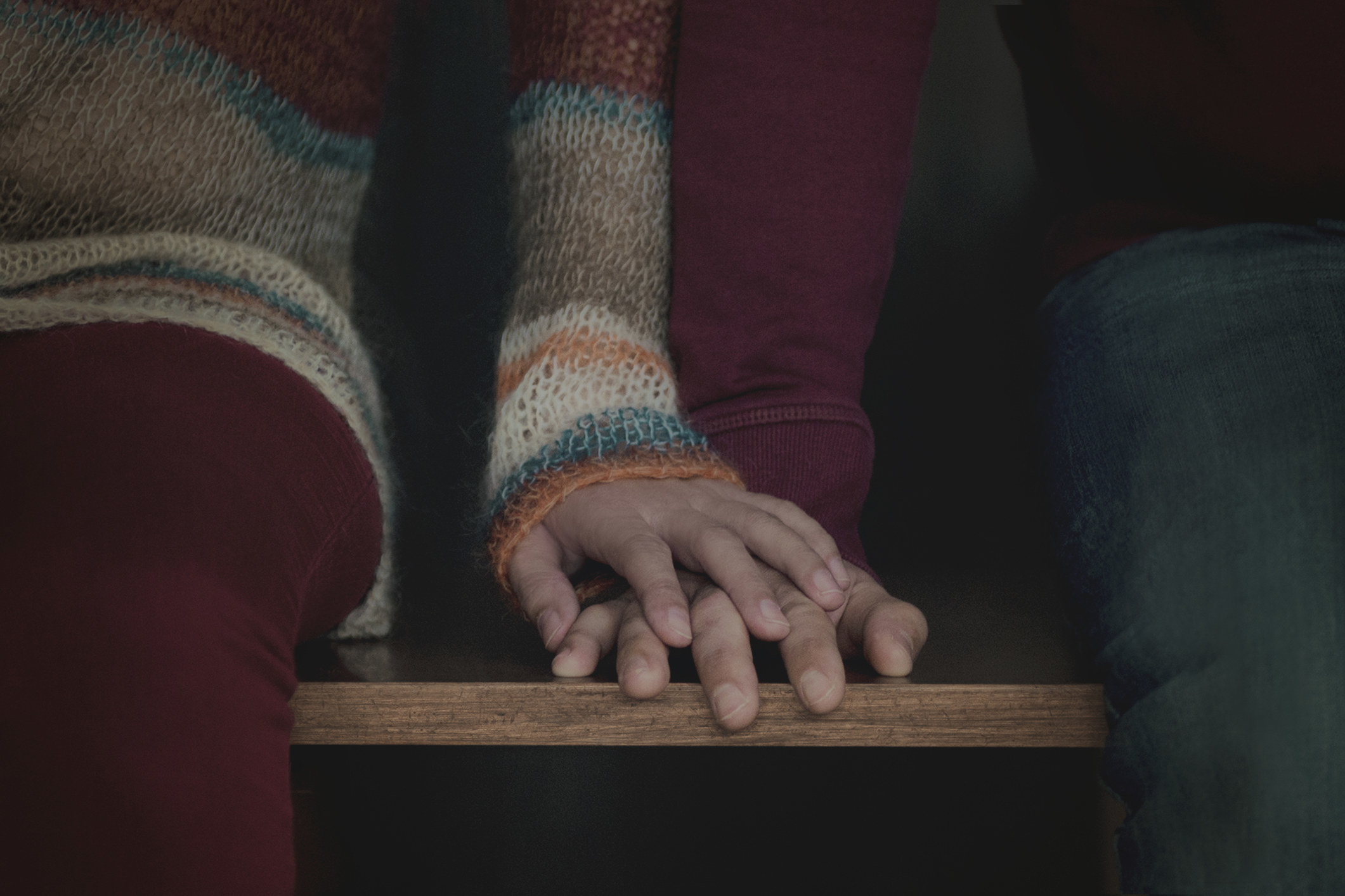 A couple sitting down and holding hands