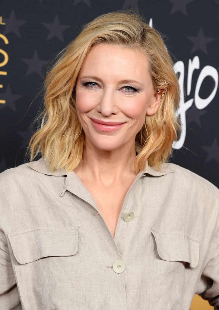 A closeup of Blanchett smiling as she wears a linen top and rocks a shoulder-length wavy bob