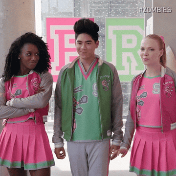 three teens in varsity outfits snapping and twirling before walking away