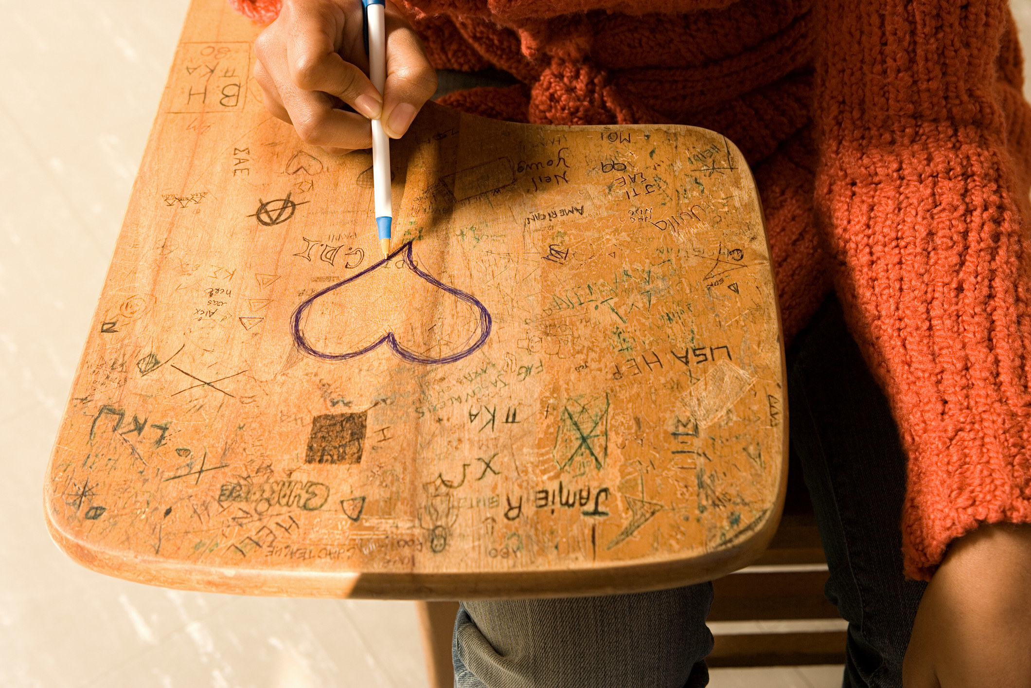 Someone drawing a heart on a desk