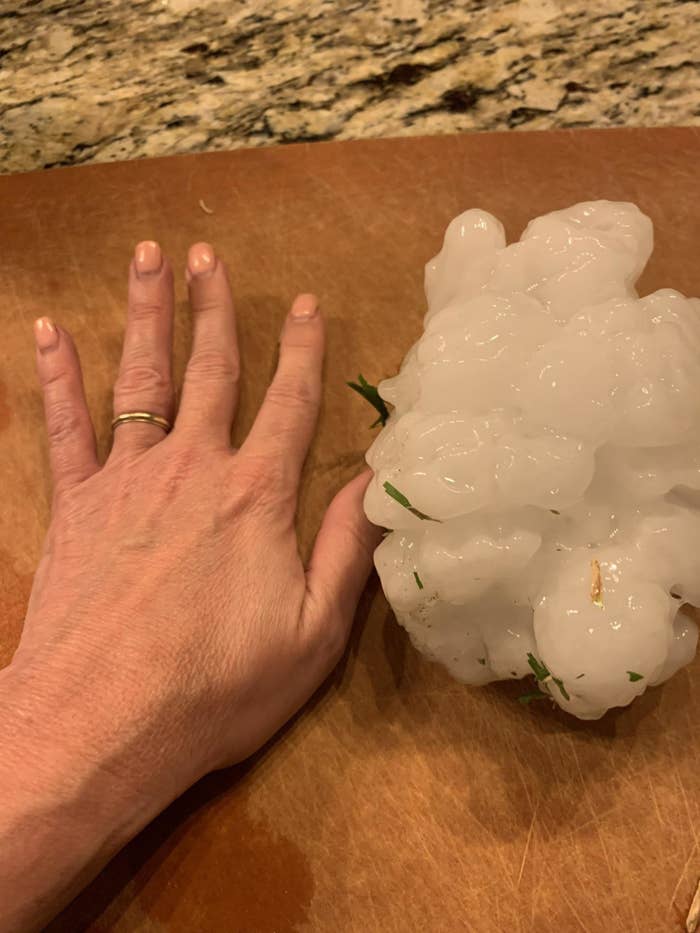 Hand next to a big piece of hail