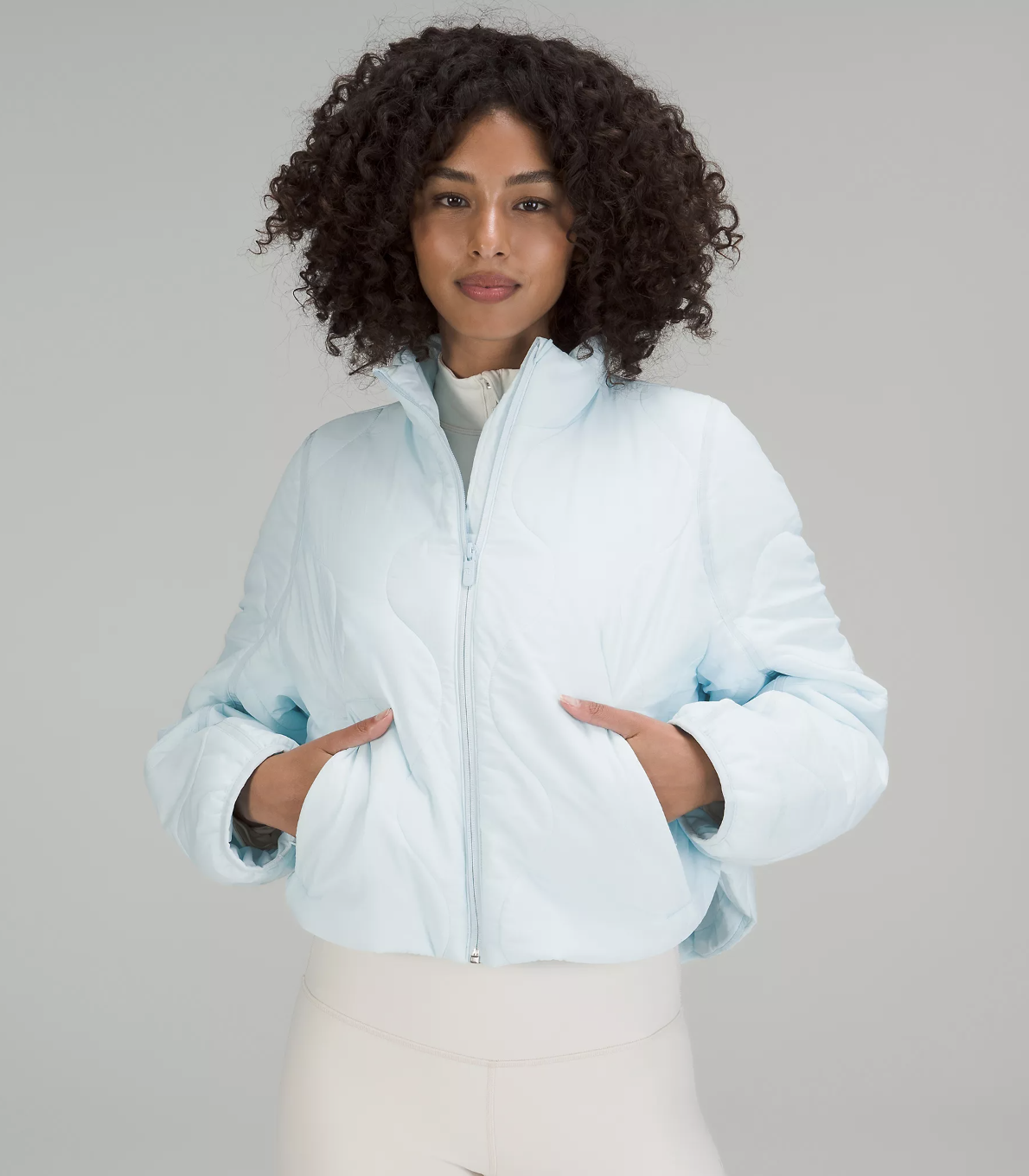 a person wearing a quilted cropped bomber jacket