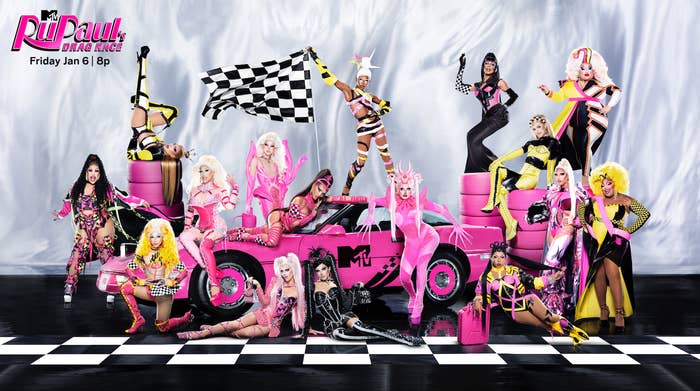 The promo shot of the current cast of RuPaul&#x27;s Drag Race in various poses around a car with an MTV logo and tires