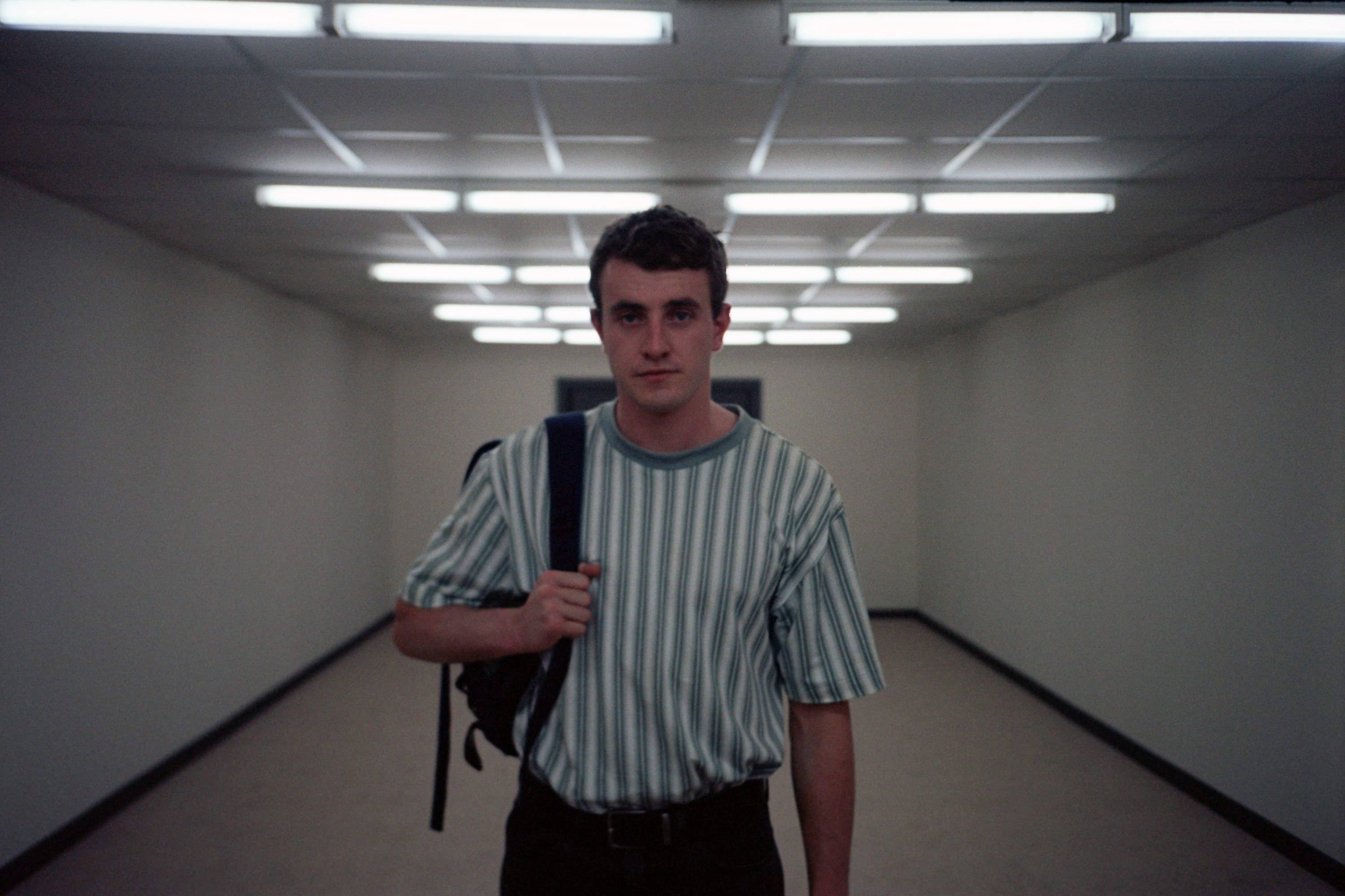 Mescal walking down a hallway while carrying a backpack on his right shoulder in a scene from &quot;Aftersun&quot;