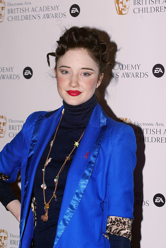 Andrea Riseborough a red carpet event wearing a turtleneck and a blazer with satin-trimmed lapels. Andrea&#x27;s hair is also swept into an updo