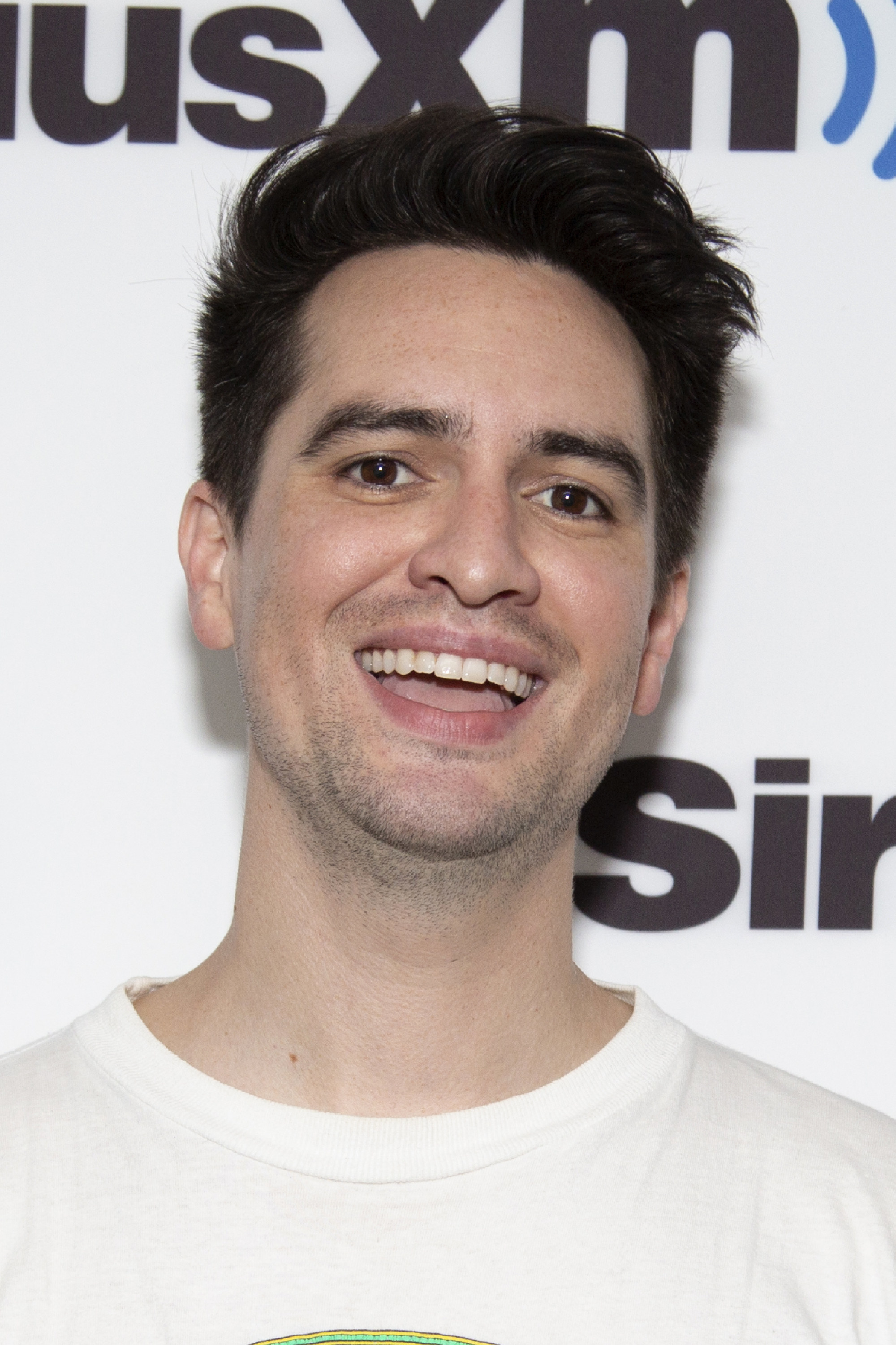 A closeup of Brendon smiling widely