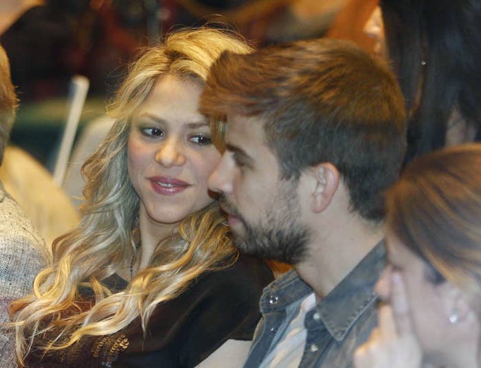 Shakira looking at Gerard with a slight smile on her face as they sit at an event