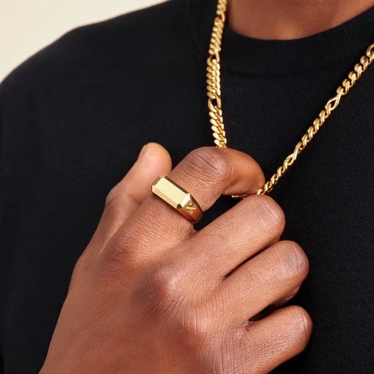 a male model wearing a gold signet ring