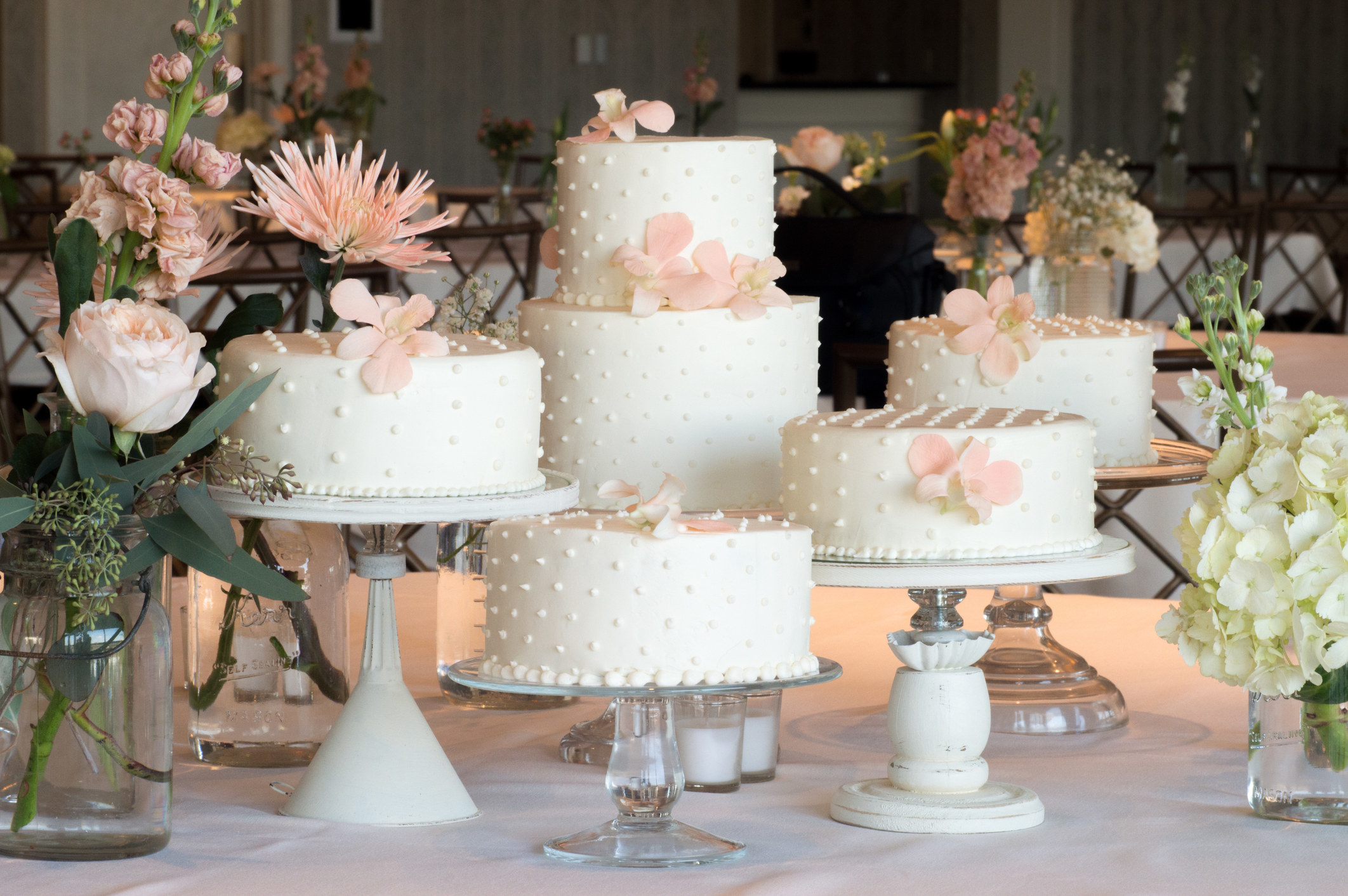 cakes on cake stands surrounded by flowers