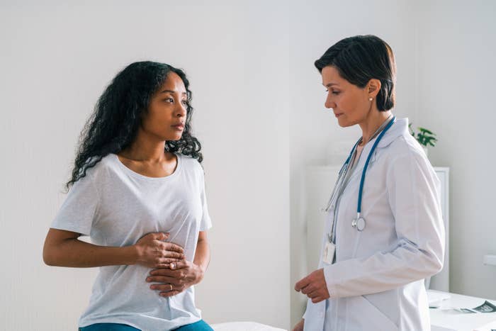 a woman touching her stomach while at the doctor