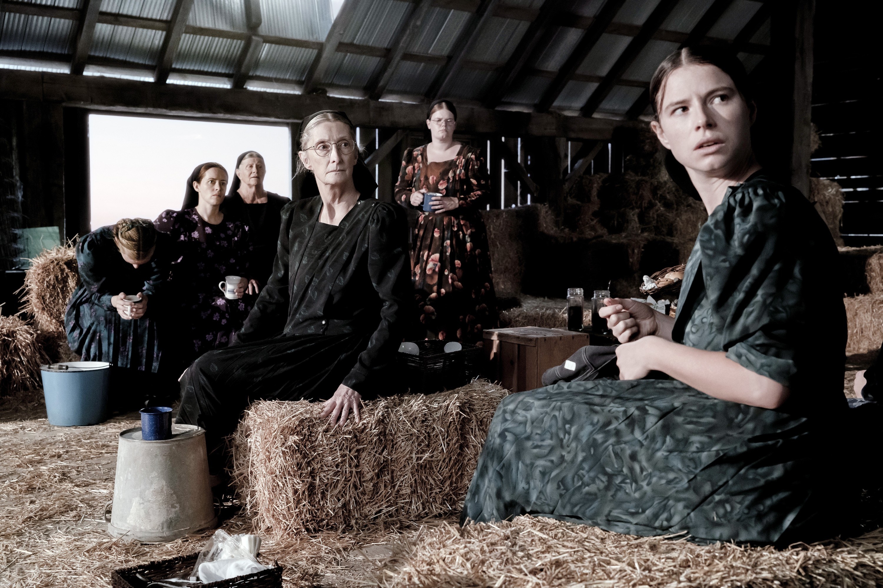 Women in a barn with bales of hay