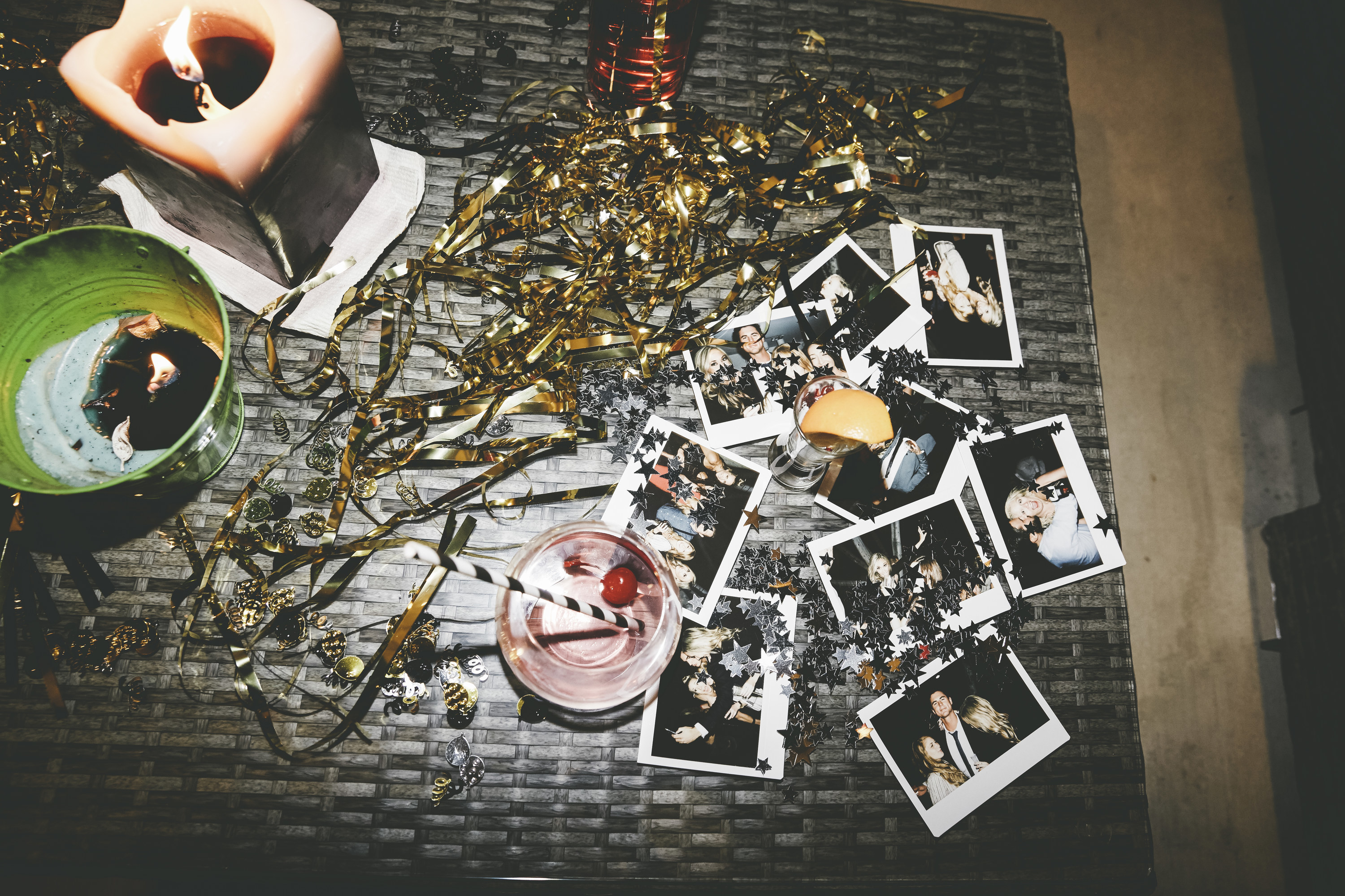 a table at the party with a drink and candle and photo