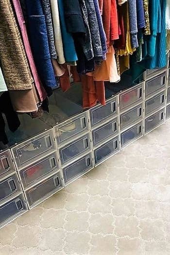 A reviewer's photo of the stackable transparent boxes being used in the bottom of a closet