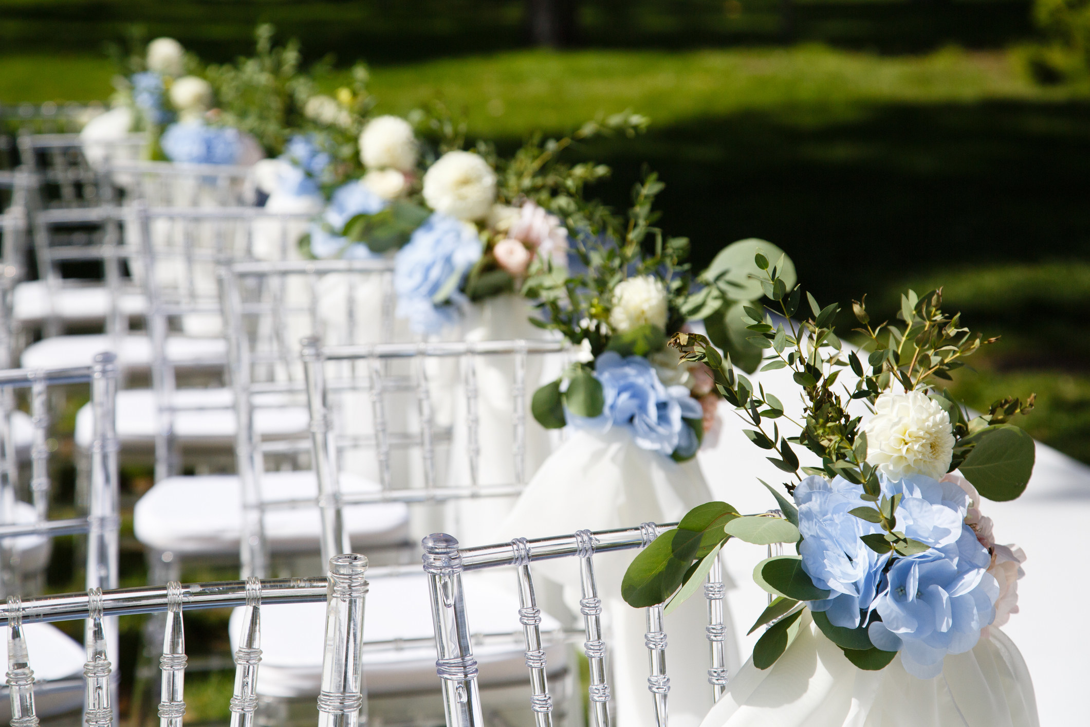 chairs lined up and tied with flowers for a ceremony
