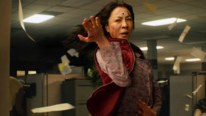 Michelle Yeoh, with a single google-y eye on her forehead, fighting in an office in a scene from &quot;Everything, Everywhere All at Once&quot;