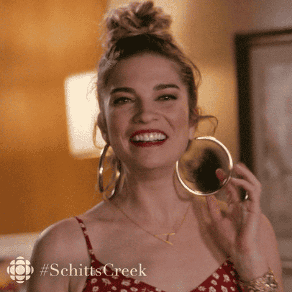 Alexis from Schitt&#x27;s Creek playing with her earrings