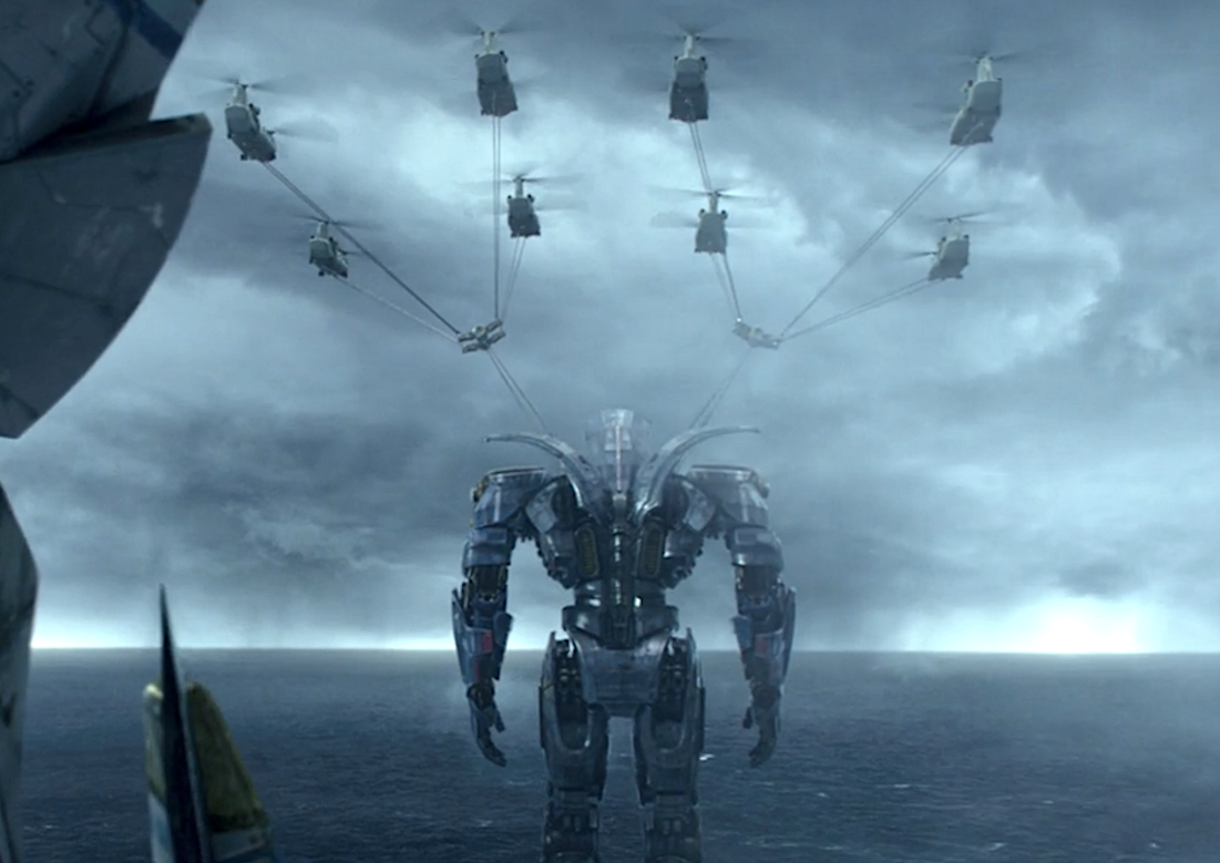 huge robot standing by the water as helicopters fly above