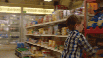 young child jumping and throwing potato chips on the floor of a grocery store from gif scene in kim&#x27;s convenience