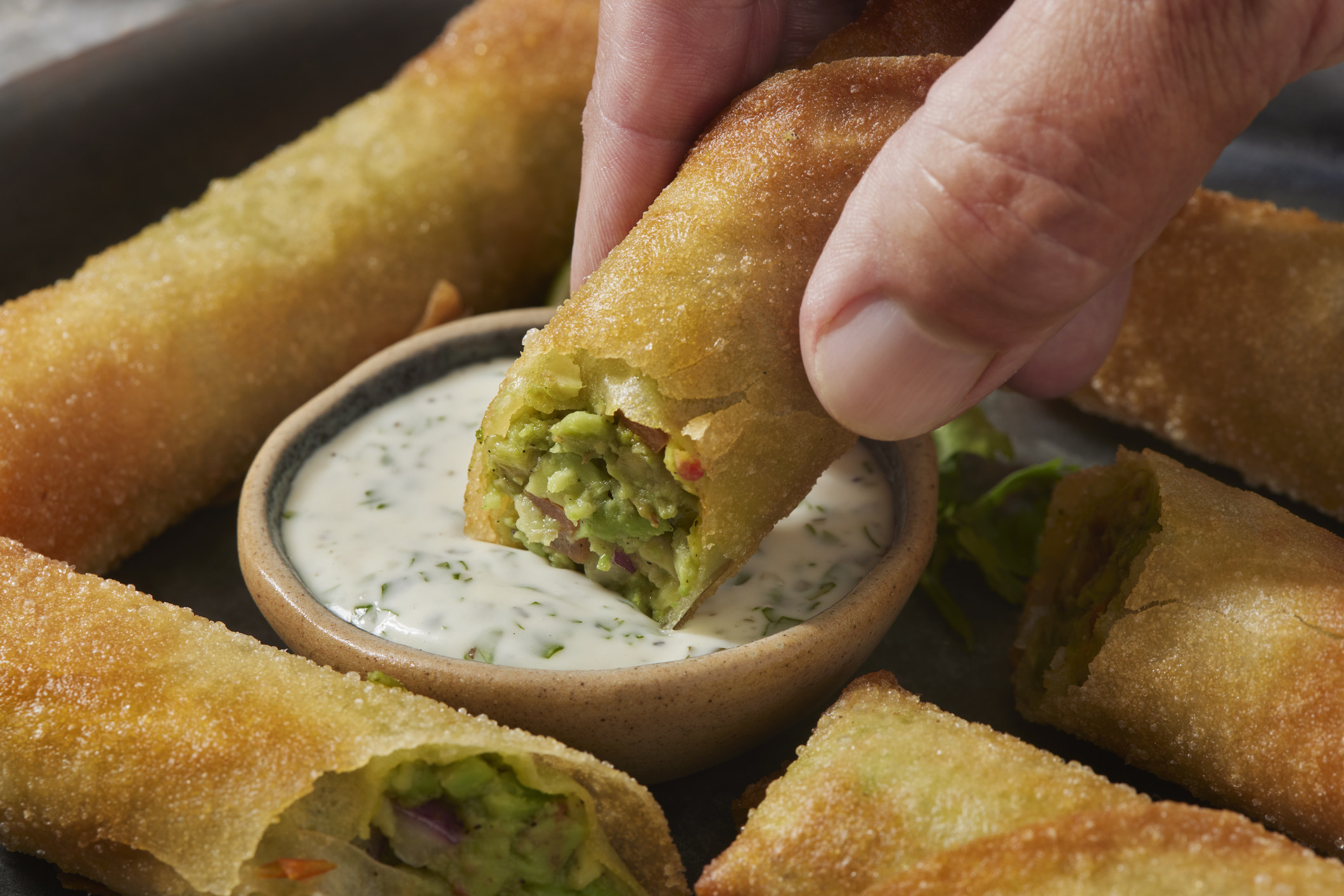 Dipping a spring roll into ranch dressing
