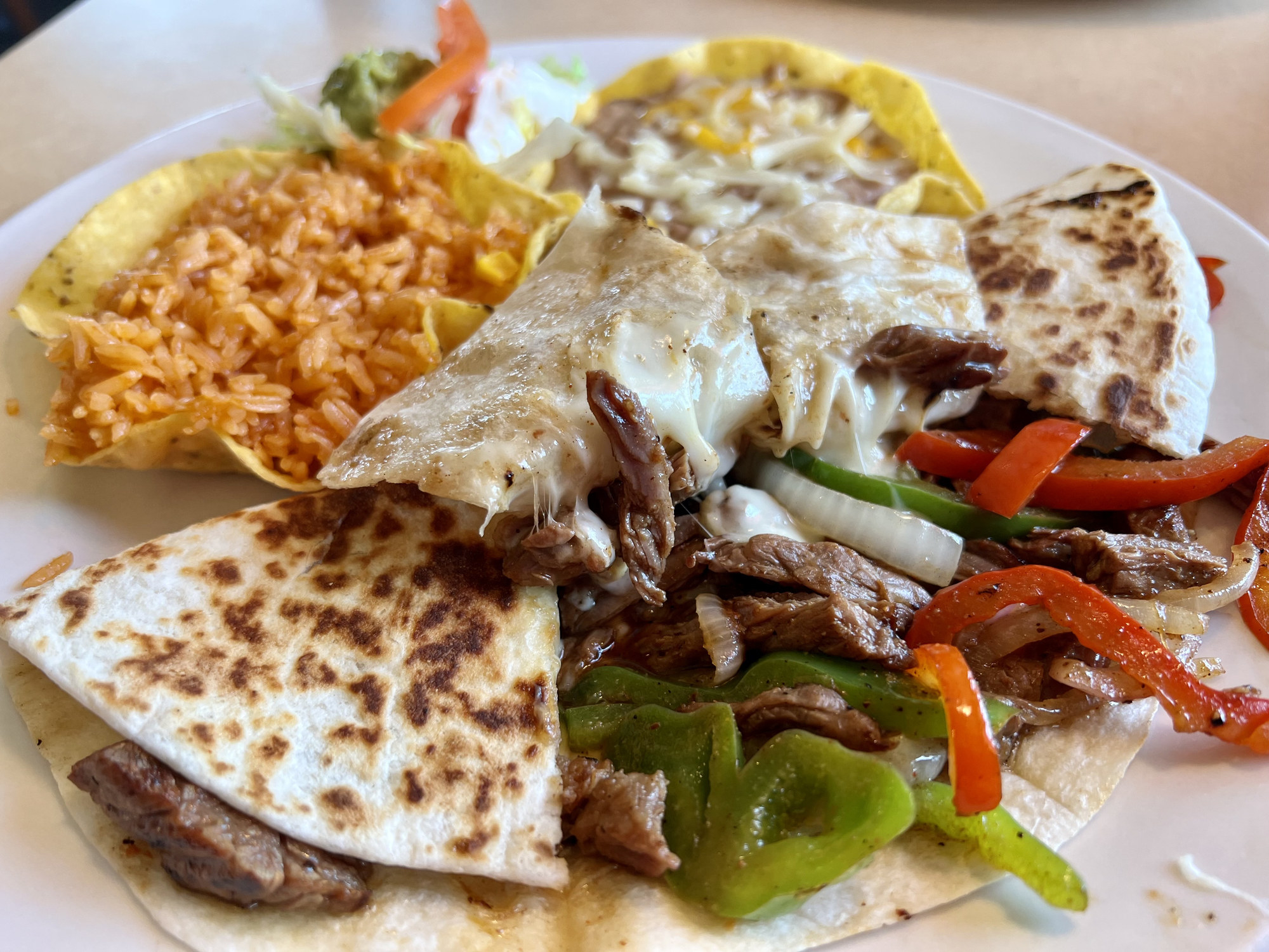 A steak quesadilla with rice and beans