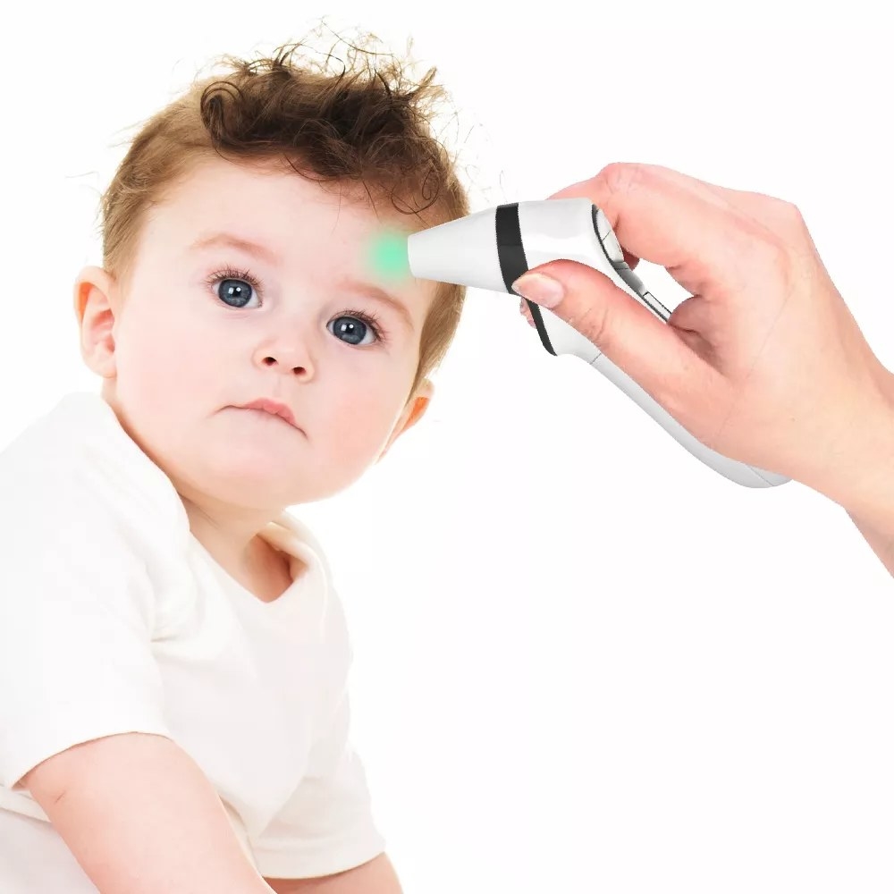 Adult hand holding white thermometer to child&#x27;s forehead