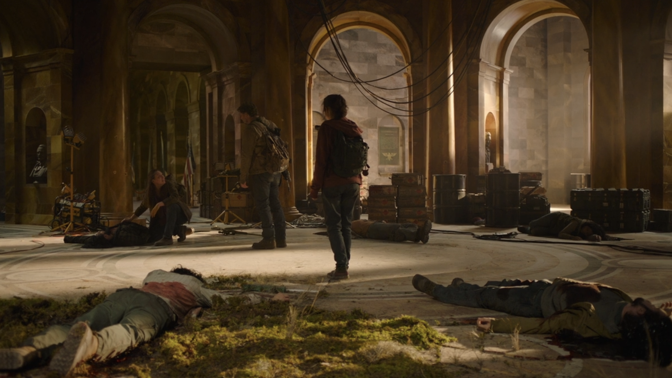 Joel and Ellie walking through a room with bodies strewn about the floor