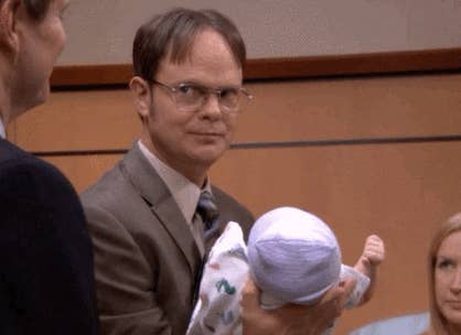 Dwight Schrute from The Office holding a baby