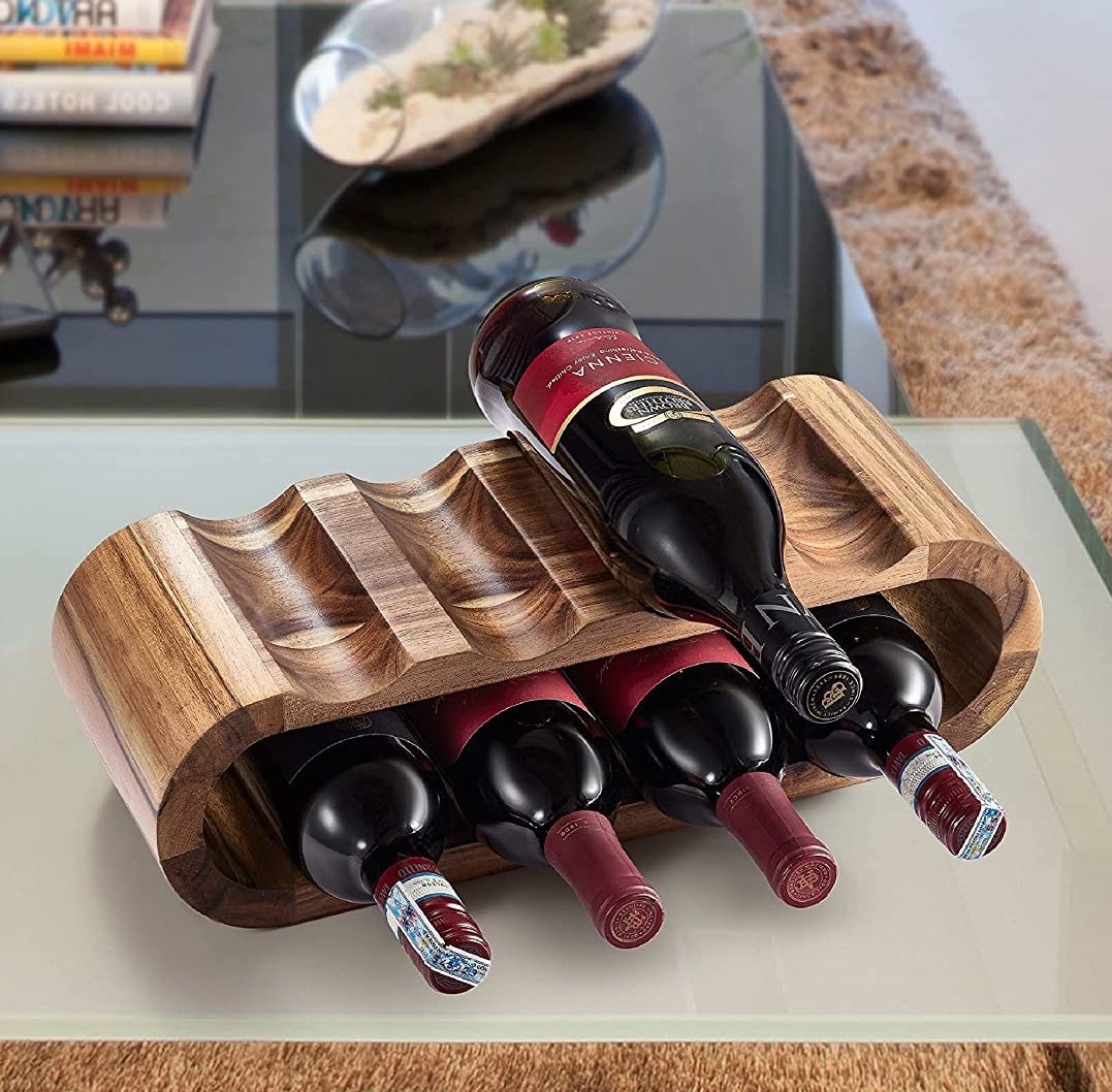 a curved wooden wine shelf with bottles of wine laying on their sides