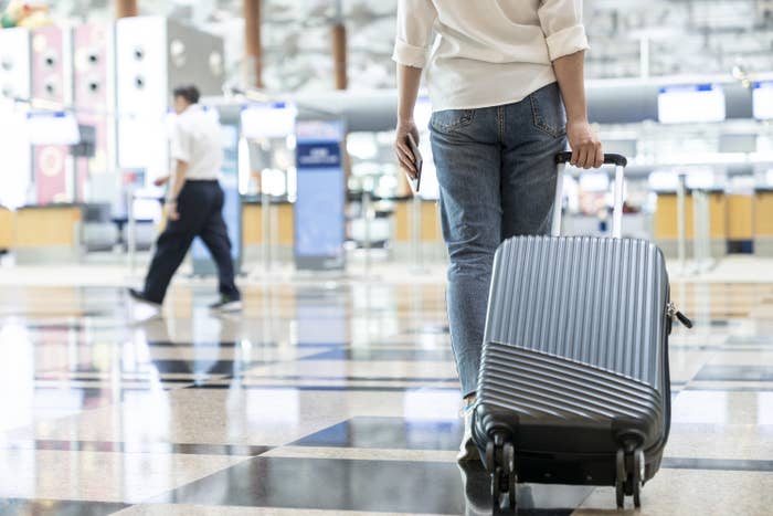 a person wheeling a suitcase through an airport