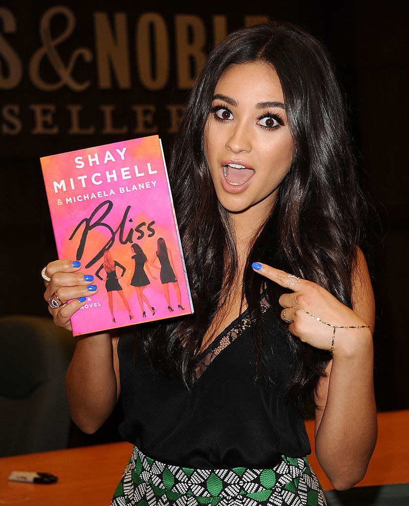 shay holding and pointing to her book