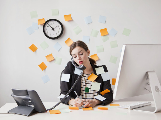 person with post-its stuck to them as they sit and write. more out at their desk