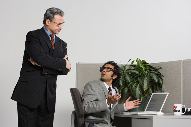 person standing over a guy in a cubicle