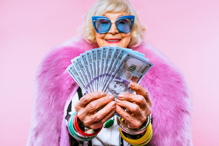 older woman fanning out $100 bills