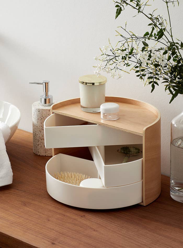 the storage box with beauty supplies in it on a wooden table