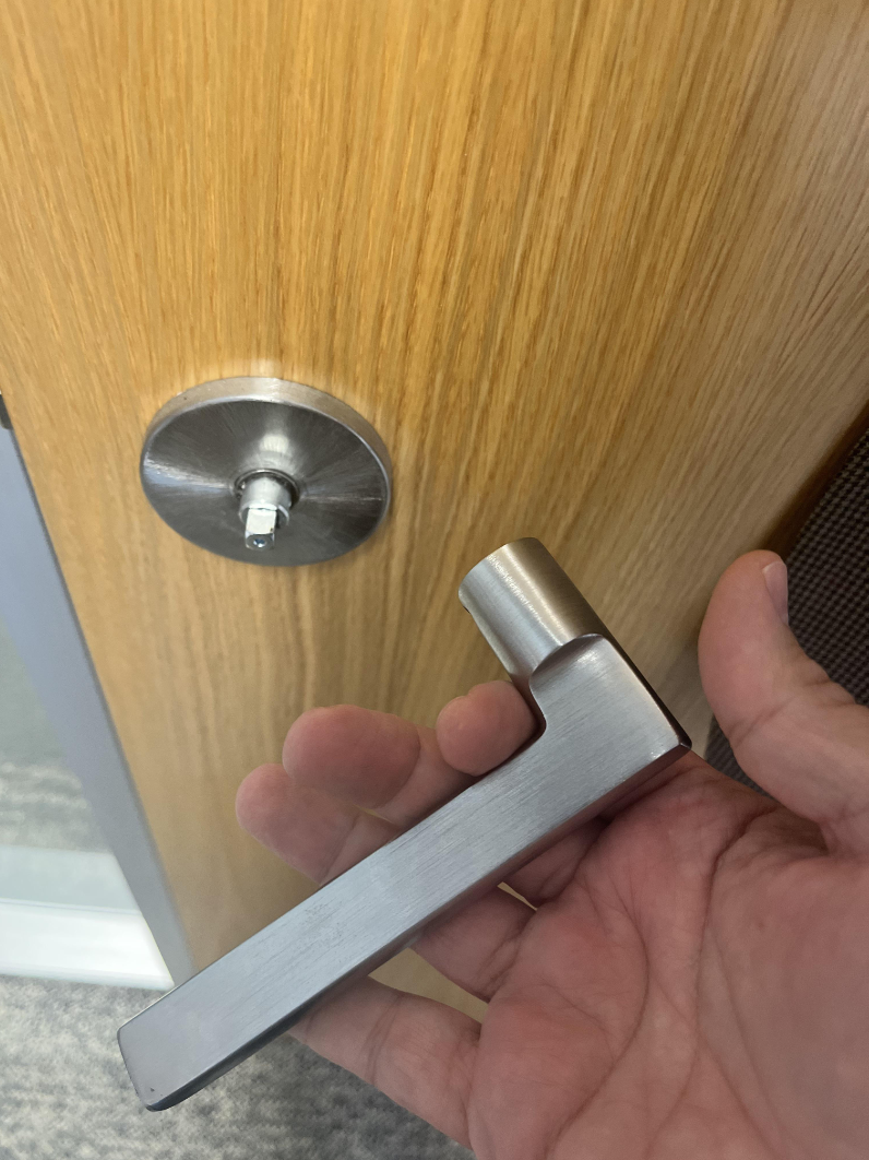 A person holding a ripped-off door handle